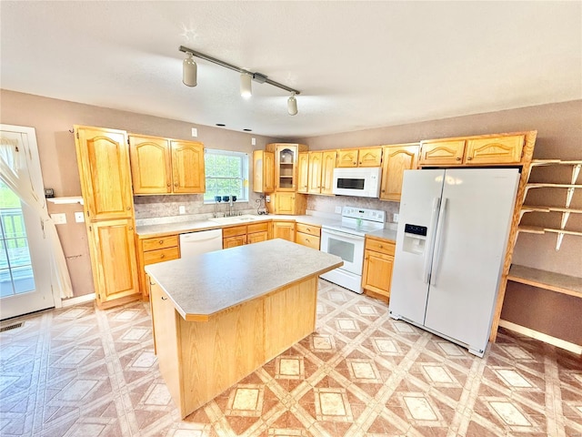 kitchen featuring a sink, light countertops, light brown cabinetry, and white appliances