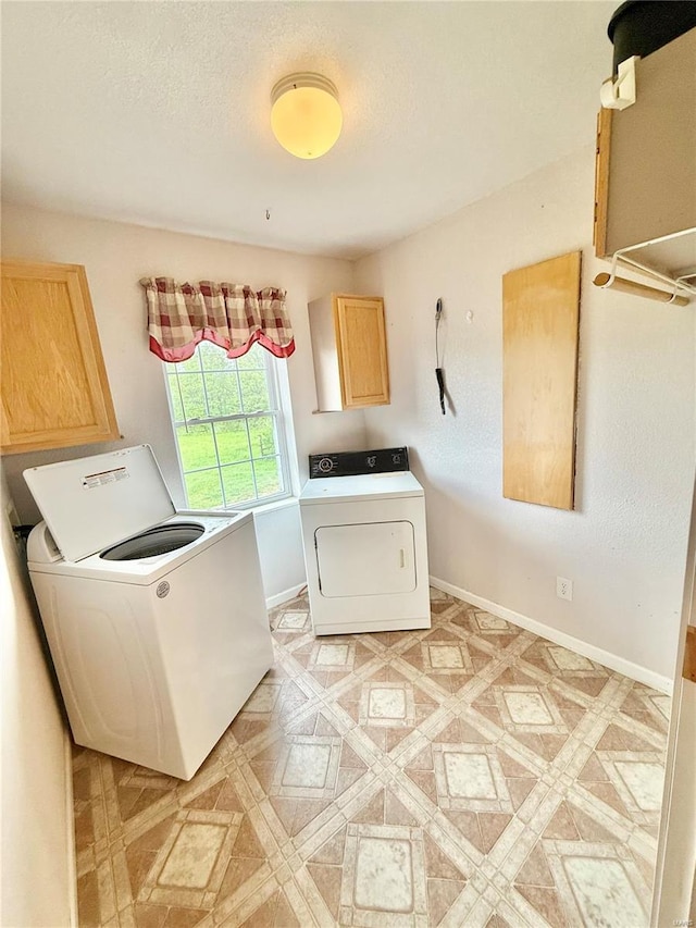 washroom with cabinet space, baseboards, and washer and dryer