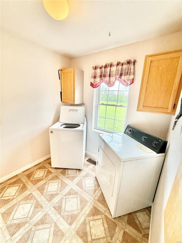 laundry area featuring cabinet space, separate washer and dryer, and baseboards