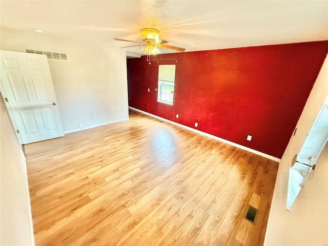 unfurnished room with baseboards, ceiling fan, visible vents, and wood finished floors