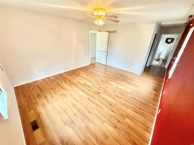 unfurnished bedroom featuring baseboards, visible vents, and wood finished floors