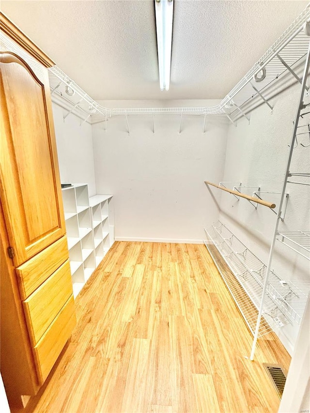 spacious closet featuring light wood finished floors and visible vents