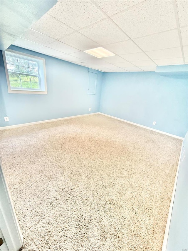 below grade area featuring baseboards and a drop ceiling