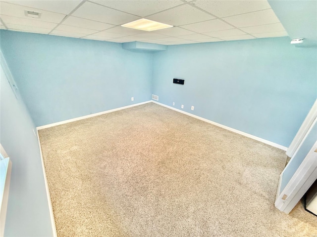 finished basement with baseboards, carpet, and a paneled ceiling