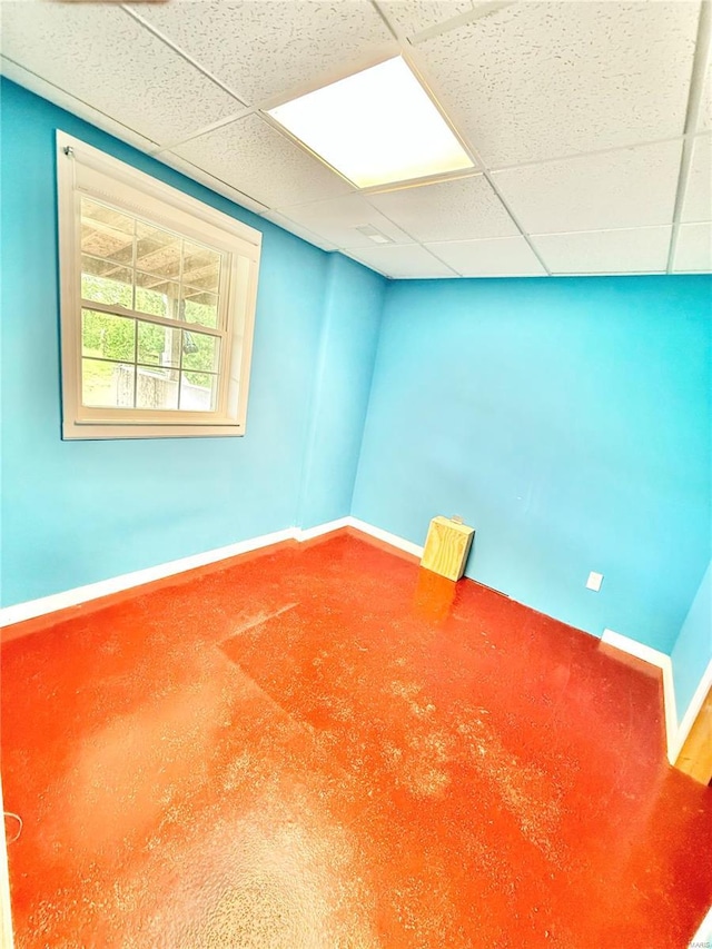 spare room featuring baseboards and a paneled ceiling