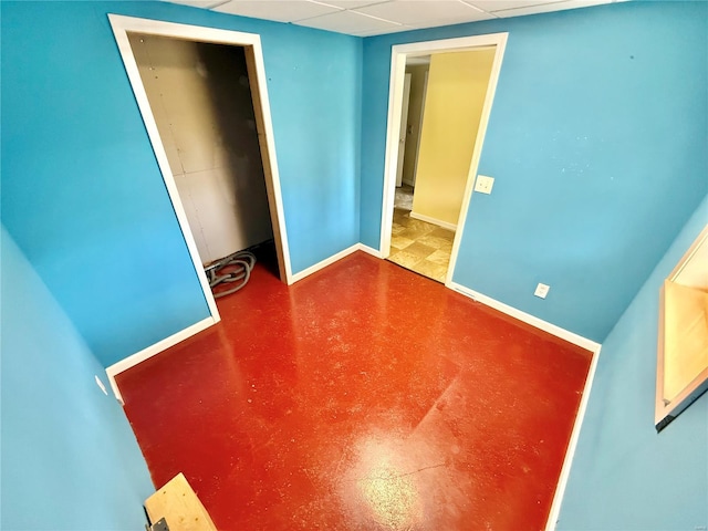 unfurnished bedroom with finished concrete floors and baseboards