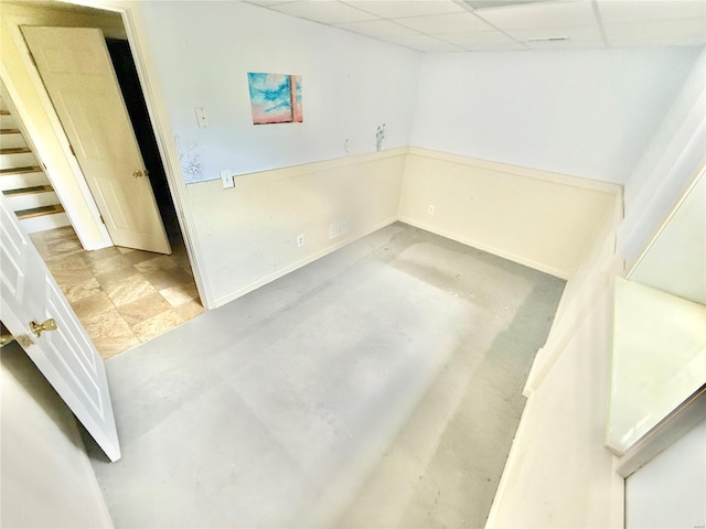 spare room with baseboards and a paneled ceiling