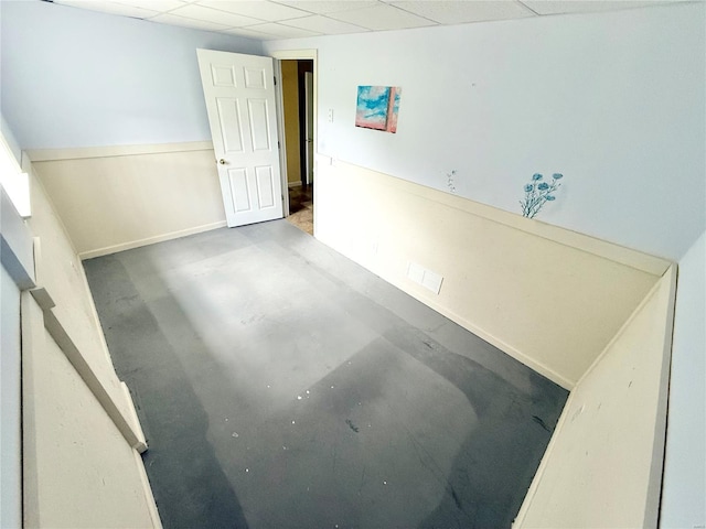 empty room featuring concrete flooring and a drop ceiling