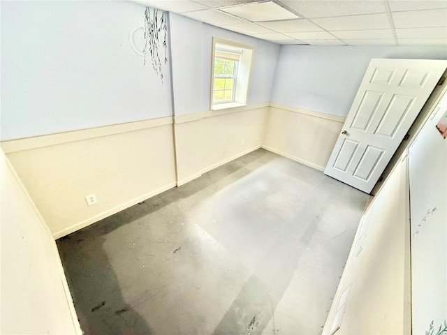 unfurnished room featuring concrete floors and a paneled ceiling