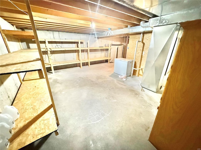 unfinished basement featuring refrigerator