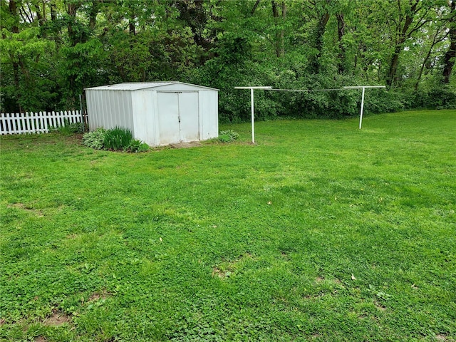 view of yard featuring fence, an outbuilding, and a storage unit