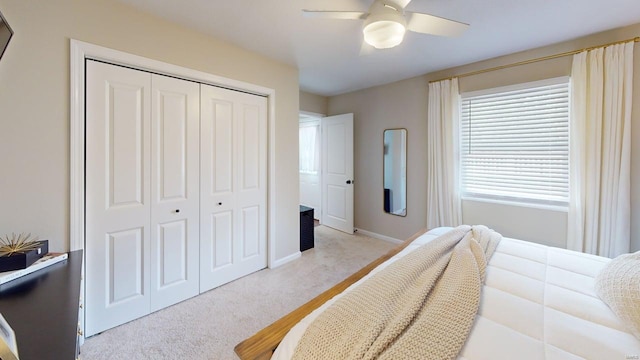 carpeted bedroom with baseboards, ceiling fan, and a closet