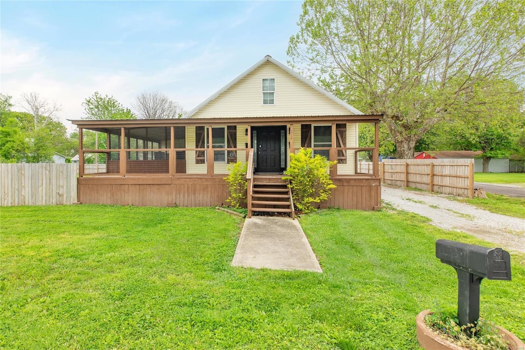 view of front facade featuring a front lawn and fence