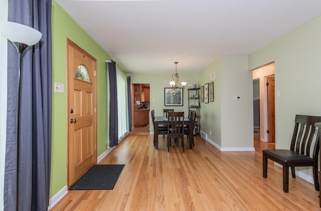 entryway with visible vents, light wood-style flooring, baseboards, and a notable chandelier