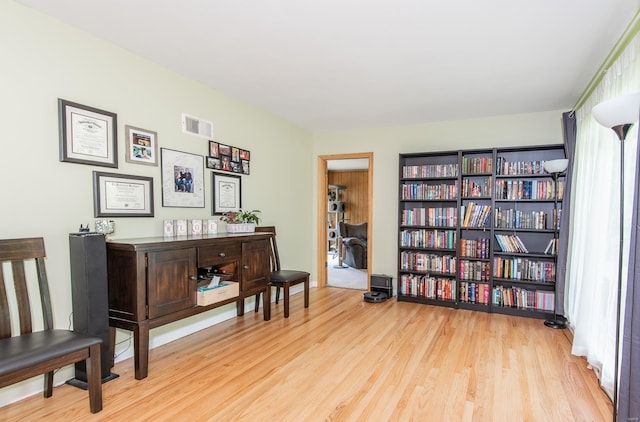 living area featuring visible vents and wood finished floors