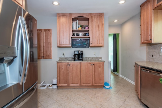 kitchen featuring recessed lighting, baseboards, light stone counters, decorative backsplash, and appliances with stainless steel finishes
