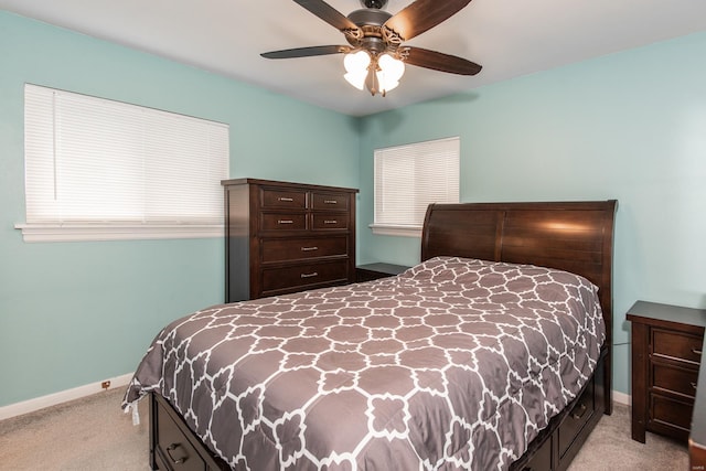 bedroom with light colored carpet, baseboards, and a ceiling fan