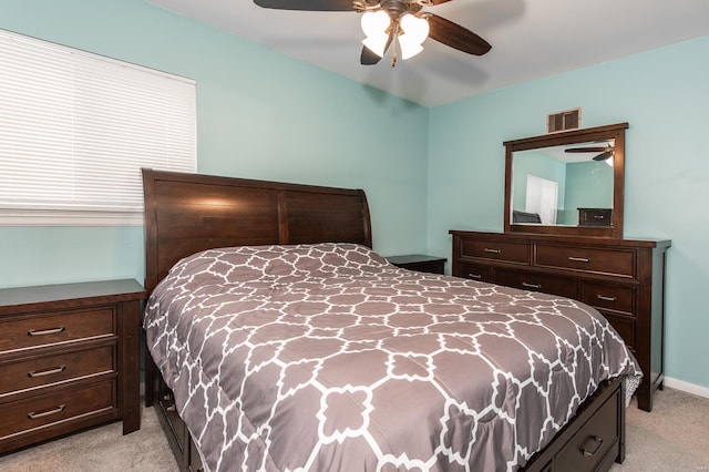 bedroom with light carpet, a ceiling fan, and visible vents