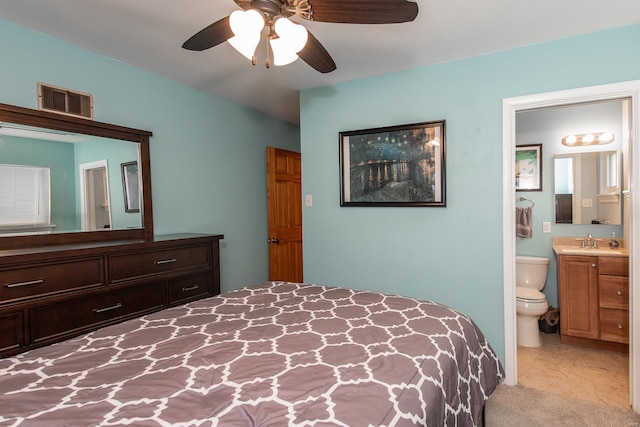 bedroom with ensuite bath, visible vents, a ceiling fan, and a sink