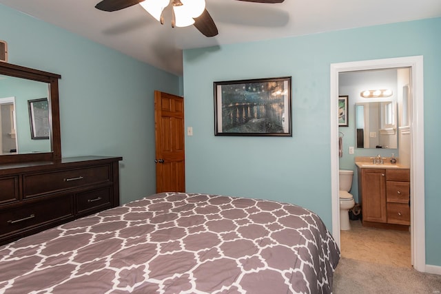 bedroom featuring light colored carpet, ensuite bathroom, a ceiling fan, and a sink