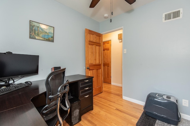 office area with a ceiling fan, baseboards, light wood-type flooring, and visible vents