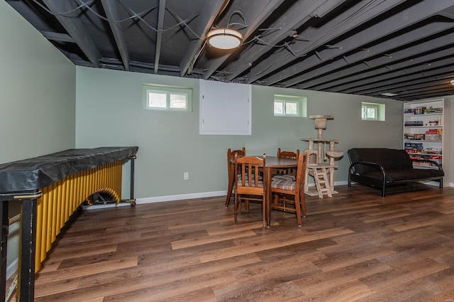 dining room with a bar, wood finished floors, and baseboards