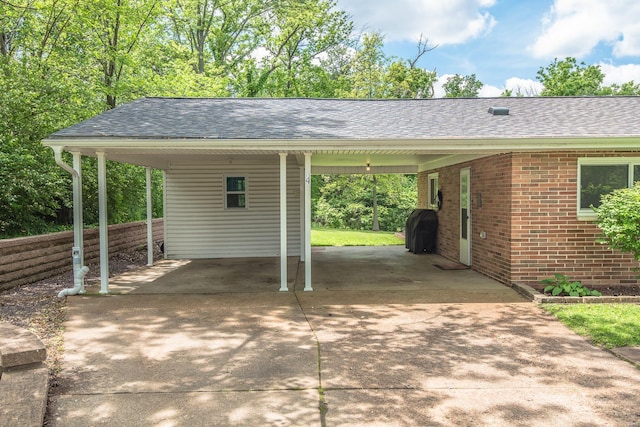 view of parking / parking lot featuring concrete driveway and a carport