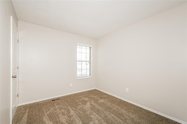 unfurnished room featuring baseboards, visible vents, and carpet