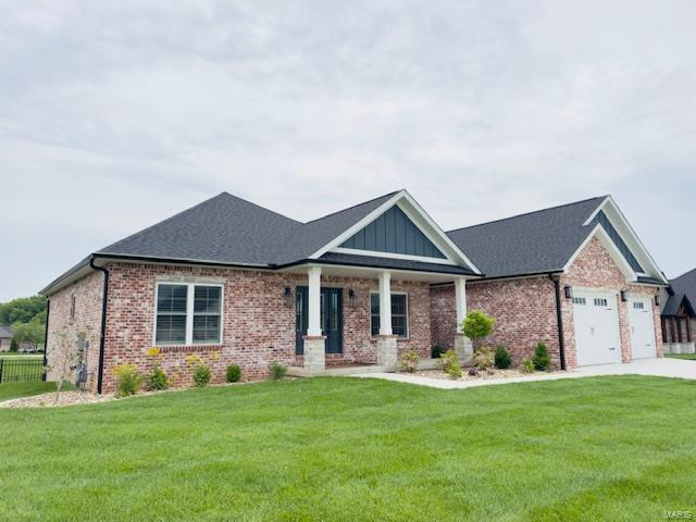 craftsman inspired home with driveway, a garage, brick siding, a front lawn, and a shingled roof