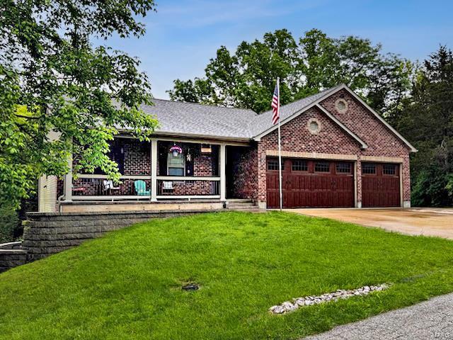 ranch-style house with a front lawn, covered porch, brick siding, an attached garage, and driveway