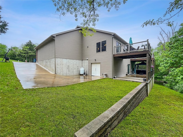 back of property featuring a yard, a patio, and a deck