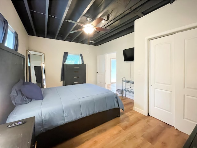 bedroom featuring ceiling fan, a closet, and wood finished floors
