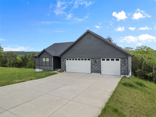 view of front of property with driveway, a front lawn, stone siding, and a garage