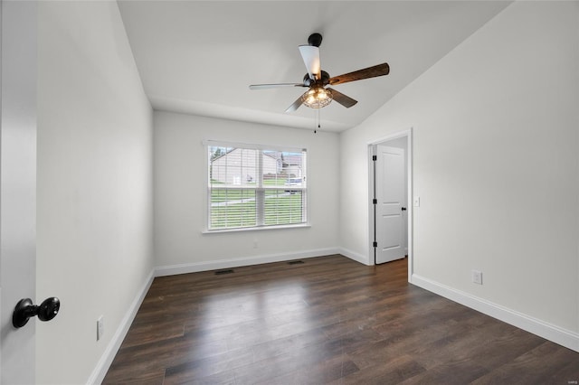 empty room featuring ceiling fan, visible vents, dark wood finished floors, baseboards, and lofted ceiling