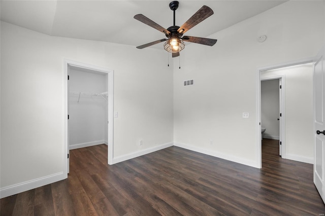 unfurnished bedroom with visible vents, baseboards, dark wood-style floors, and a spacious closet