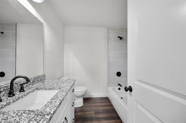 full bathroom featuring wood finished floors, shower / washtub combination, vanity, baseboards, and toilet