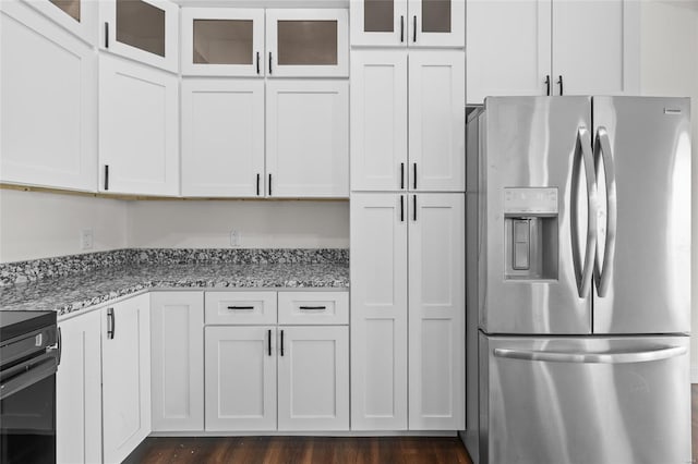 kitchen featuring stainless steel fridge with ice dispenser, light stone counters, and white cabinetry
