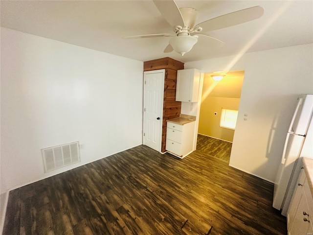 interior space with ceiling fan, dark wood-style flooring, and visible vents
