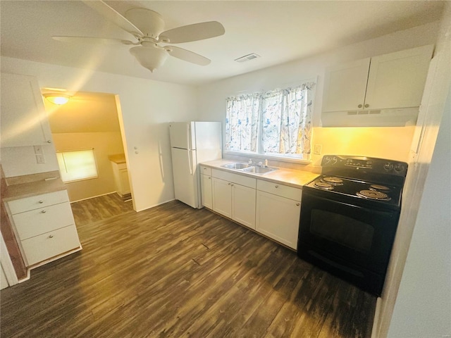 kitchen featuring black / electric stove, dark wood finished floors, a sink, freestanding refrigerator, and under cabinet range hood