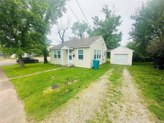 bungalow with a detached garage, driveway, an outdoor structure, and a front lawn