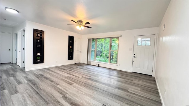 foyer with baseboards, a ceiling fan, wood finished floors, and visible vents