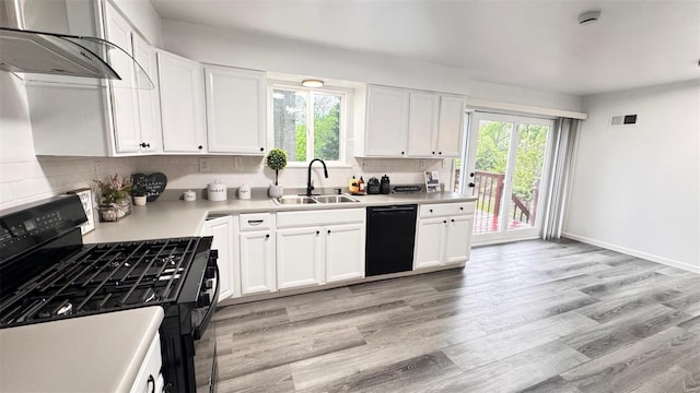 kitchen with visible vents, range hood, a sink, backsplash, and black appliances