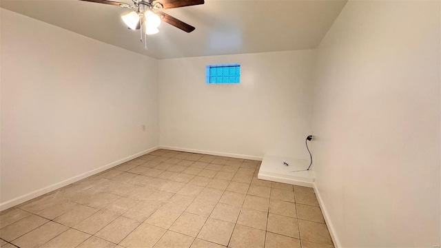 spare room featuring baseboards, a ceiling fan, and light tile patterned flooring