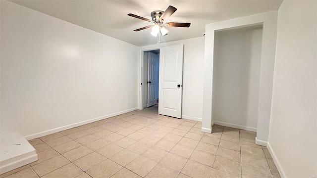 unfurnished bedroom with light tile patterned floors, baseboards, and ceiling fan