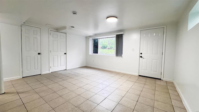 foyer featuring baseboards and light tile patterned flooring