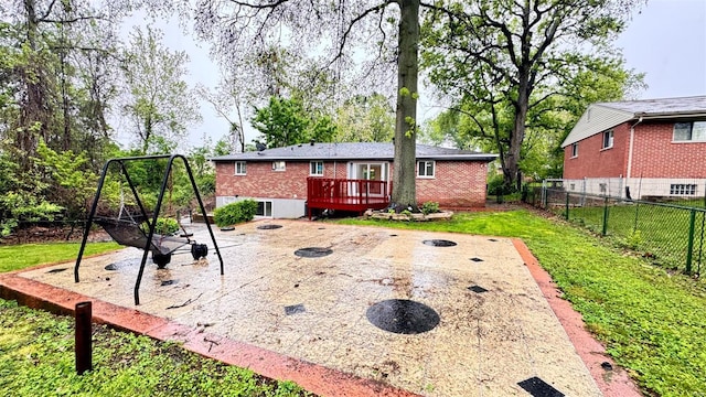 back of property featuring fence, a wooden deck, a patio, and brick siding