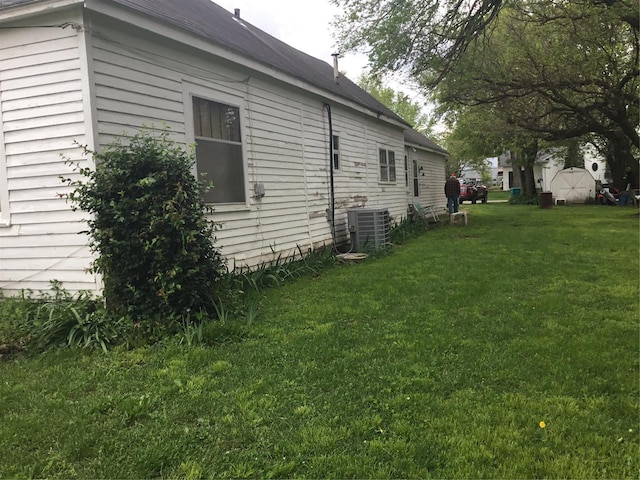 view of side of home featuring a lawn and central air condition unit