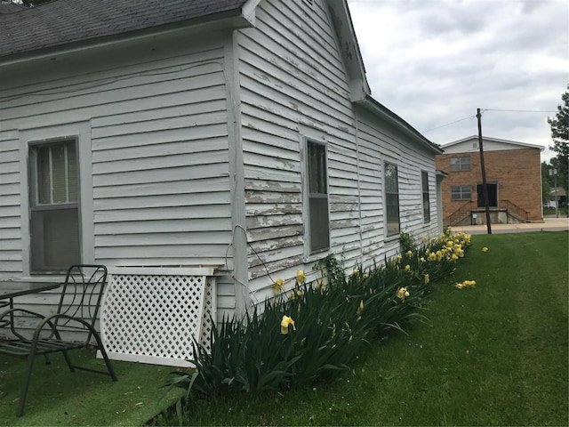 view of side of home with a yard