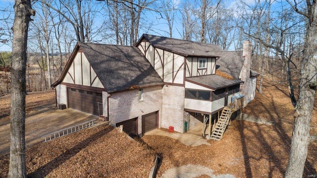 view of property exterior featuring a sunroom, roof with shingles, and a chimney