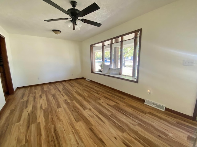 unfurnished bedroom featuring visible vents, a ceiling fan, baseboards, and wood finished floors